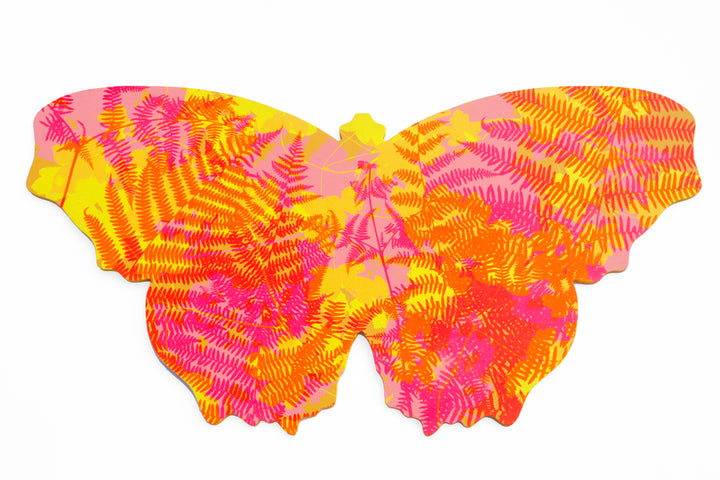 A butterfly shaped artwork with brightly coloured, screenprinted layered silhouettes of wild plants. The predominant colours are pink, red, yellow and orange.