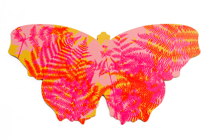 A butterfly shaped artwork with brightly coloured, screenprinted layered silhouettes of wild plants. The predominant colours are pink, red and orange.